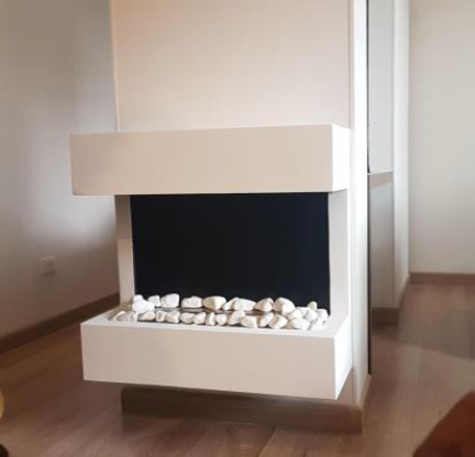 Chimenea moderna blanca con piedras decorativas en salón.